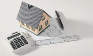 Modello di casa, calcolatrice, righello e penna su progetto. Pianifica la tua ristrutturazione con sconto in fattura.
