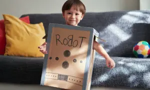 Bambino sorridente con travestimenti cartoni animati fai da te da robot, creato con una scatola di cartone.