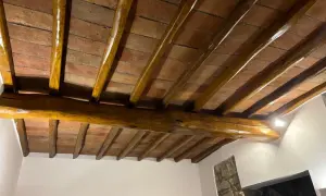 Travi in legno con tetto in cotto, protette da un efficace trattamento antitarlo per preservare la bellezza storica.