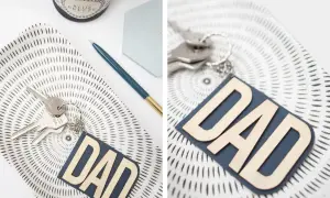 Portachiavi fai da te per la festa del papà con scritta "DAD" in legno su fondo blu. Un'idea regalo originale e personalizzata.