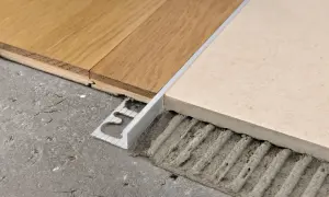 Profili metallici per accostare pavimenti diversi, come parquet e piastrelle, garantendo una finitura pulita e sicura.