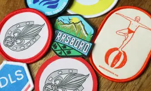 Collezione di toppe termoadesive su poliestere con vari design: un cavallo, montagne, un tuffatore e lettere.