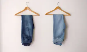 Due paia di jeans appesi: uno scuro, l'altro chiaro. Scopri come scolorire i jeans senza candeggina per ottenere questo effetto.
