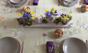 Tavola apparecchiata per Pasqua con centrotavola di fiori e uccellini, idee per lavoretti per pasqua.