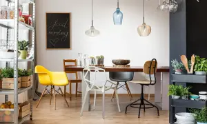 Tavola apparecchiata con lampadario decentrato soluzioni moderne. Sedie colorate e lavagna con scritta "Good morning".