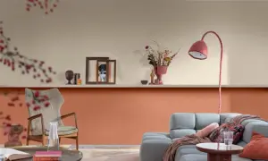 Soggiorno con pareti bicolore: la parte inferiore è color terracotta, quella superiore color crema. Arredamento moderno con divano grigio e poltrona.