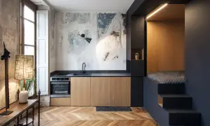 Cucina moderna con letto a soppalco, un esempio di idee arredo casa piccola. Pareti grezze, mobili in legno e dettagli industriali.