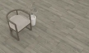 Sedia beige e vaso con fiori secchi su un pavimento in laminato grigio effetto legno. Lo spessore del parquet laminato è ideale per ogni ambiente.