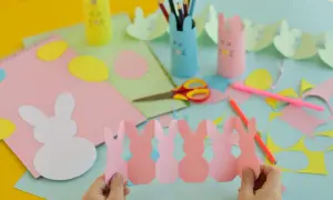 Bambini creano lavoretti di Pasqua scuola primaria: coniglietti di carta, uova colorate e porta-matite a tema.
