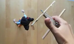 Mano che muove un marionette fai da te con fili di controllo in legno.