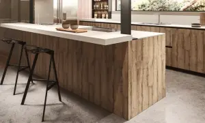 Modern kitchen island with wood-look melamine cabinets and white countertop, featuring black bar stools.