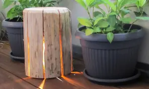 Lampada tronco legno fai da te illumina con calore il deck, creando un'atmosfera accogliente tra le piante in vaso.