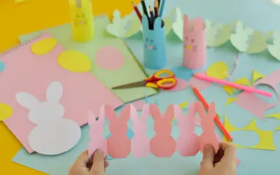 Bambini creano lavoretti di Pasqua scuola primaria: coniglietti di carta, uova colorate e porta-matite a tema.