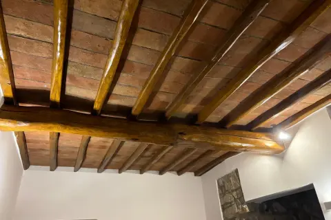 Travi in legno con tetto in cotto, protette da un efficace trattamento antitarlo per preservare la bellezza storica.