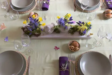 Tavola apparecchiata per Pasqua con centrotavola di fiori e uccellini, idee per lavoretti per pasqua.