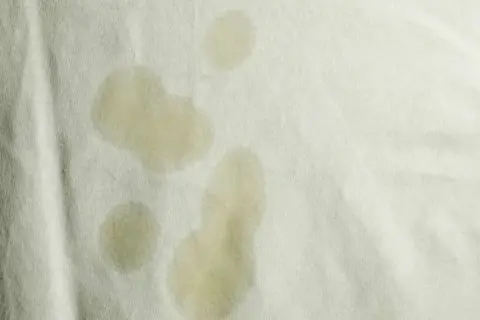 Macchie gialle sulla biancheria intima, forse dovute a sudore o a un lavaggio non perfetto.
