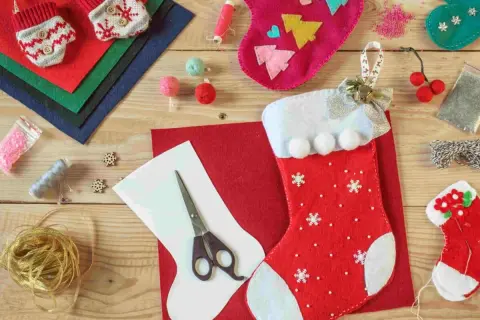 Materiali per calze Befana personalizzate fai da te: feltro, forbici, nastri, bottoni e perline per creare decorazioni uniche.