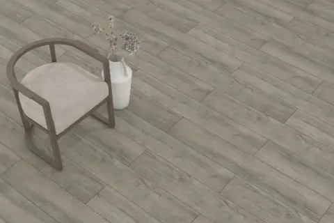 Sedia beige e vaso con fiori secchi su un pavimento in laminato grigio effetto legno. Lo spessore del parquet laminato è ideale per ogni ambiente.