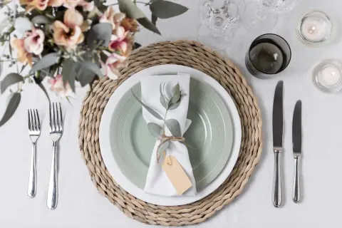 Tovagliolo decorato con rametto e cartellino, un'idea per portatovaglioli fai da te. Tavola apparecchiata con fiori, candele e posate.
