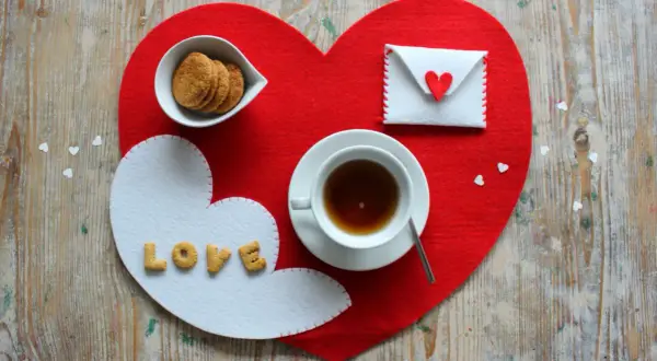 Tovagliette colazione fai da te a forma di cuore, con biscotti, tè e una busta con un cuore.