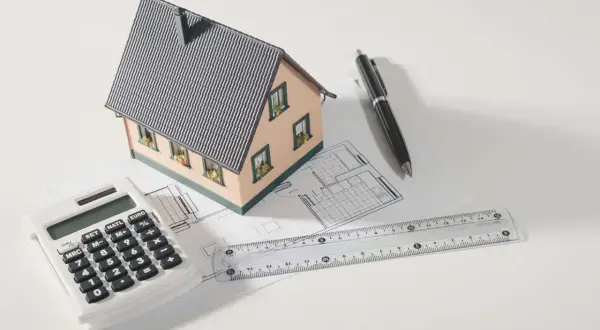 Modello di casa, calcolatrice, righello e penna su progetto. Pianifica la tua ristrutturazione con sconto in fattura.