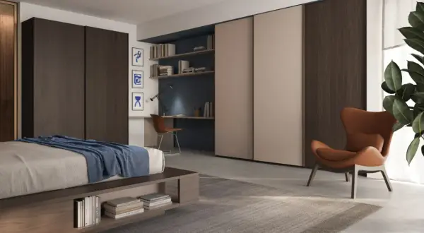 Un accogliente angolo lettura camera da letto con poltrona in pelle, scrivania e libreria a muro.