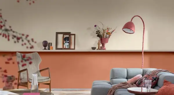 Soggiorno con pareti bicolore: la parte inferiore è color terracotta, quella superiore color crema. Arredamento moderno con divano grigio e poltrona.