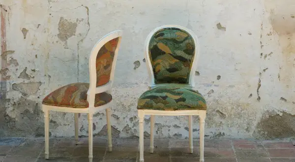Due sedie con tessuti colorati e fantasiosi, perfette come idee per ricoprire sedie e dare un tocco unico all'arredo.