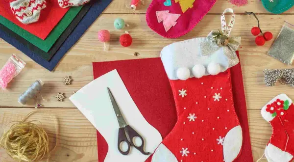 Materiali per calze Befana personalizzate fai da te: feltro, forbici, nastri, bottoni e perline per creare decorazioni uniche.