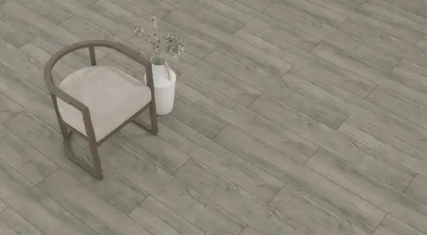 Sedia beige e vaso con fiori secchi su un pavimento in laminato grigio effetto legno. Lo spessore del parquet laminato è ideale per ogni ambiente.