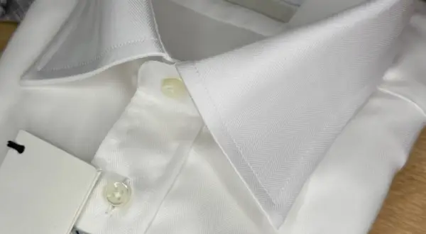 Dettaglio di una camicia bianca con colletto e bottoni. Un'idea su come sbiancare una camicia bianca ingiallita.