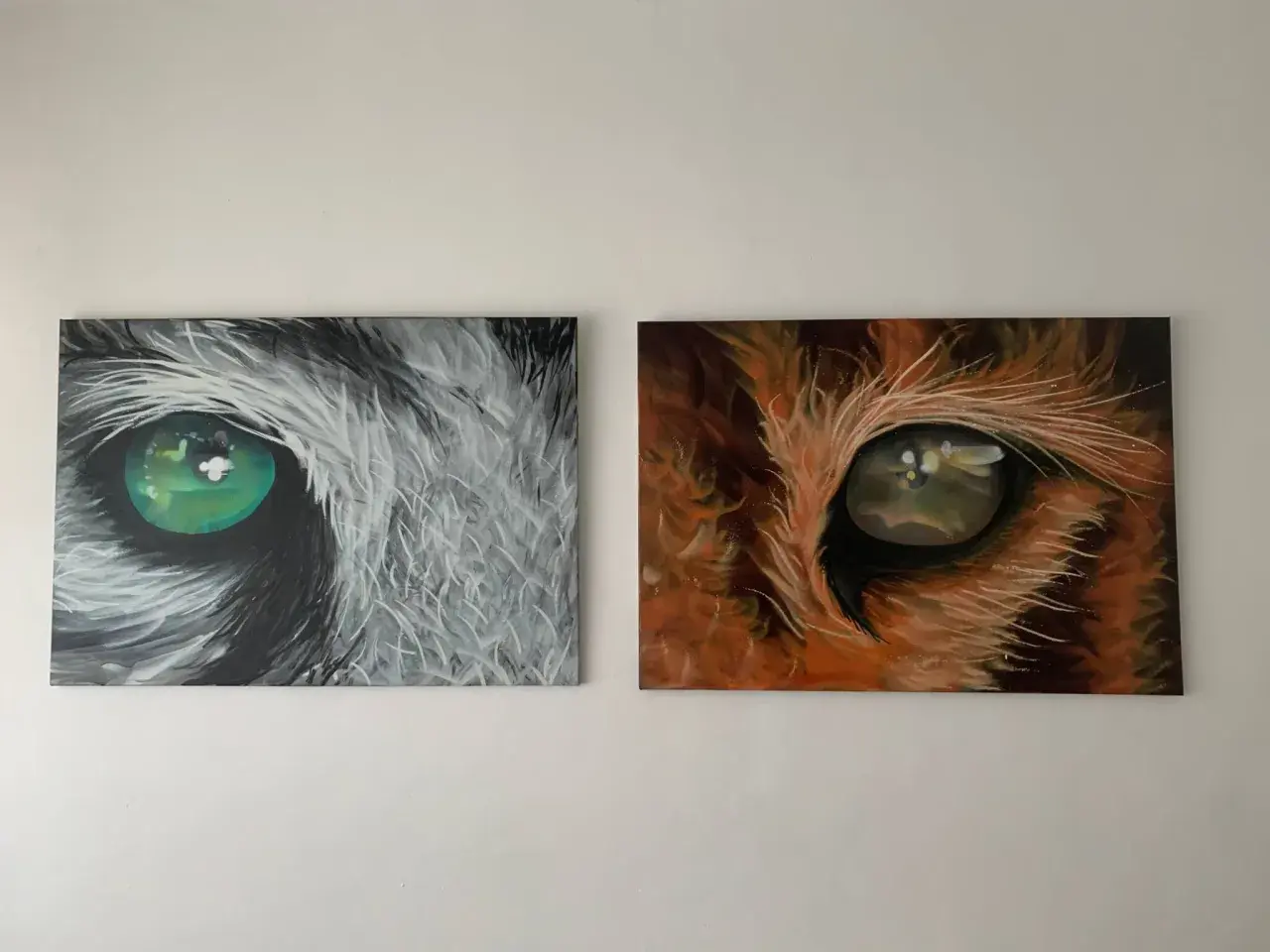 Due tele con occhi di animali: uno grigio con iride verde brillante, l'altro arancione con iride dorata. Idee murales semplici e d'impatto.