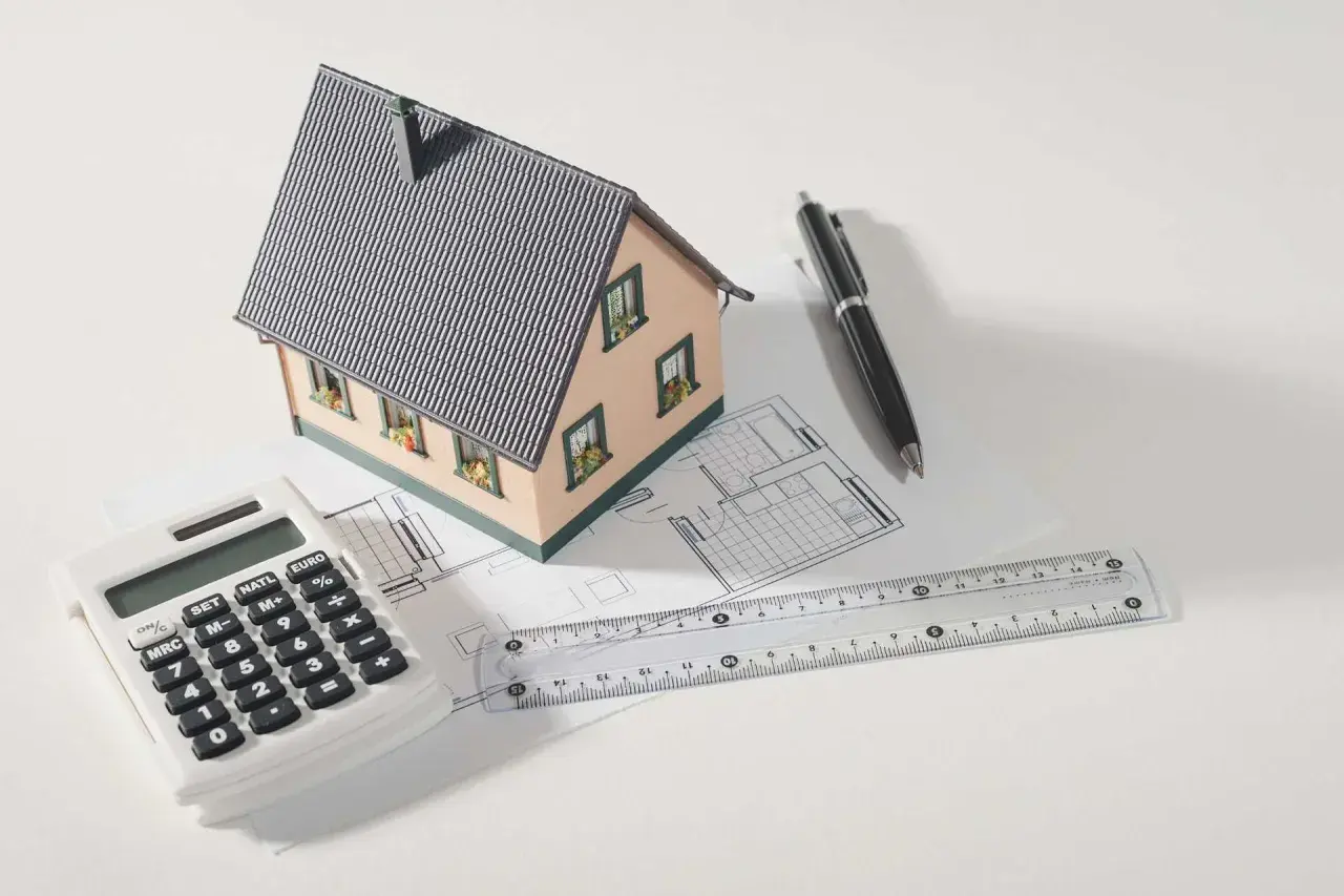 Modello di casa, calcolatrice, righello e penna su progetto. Pianifica la tua ristrutturazione con sconto in fattura.