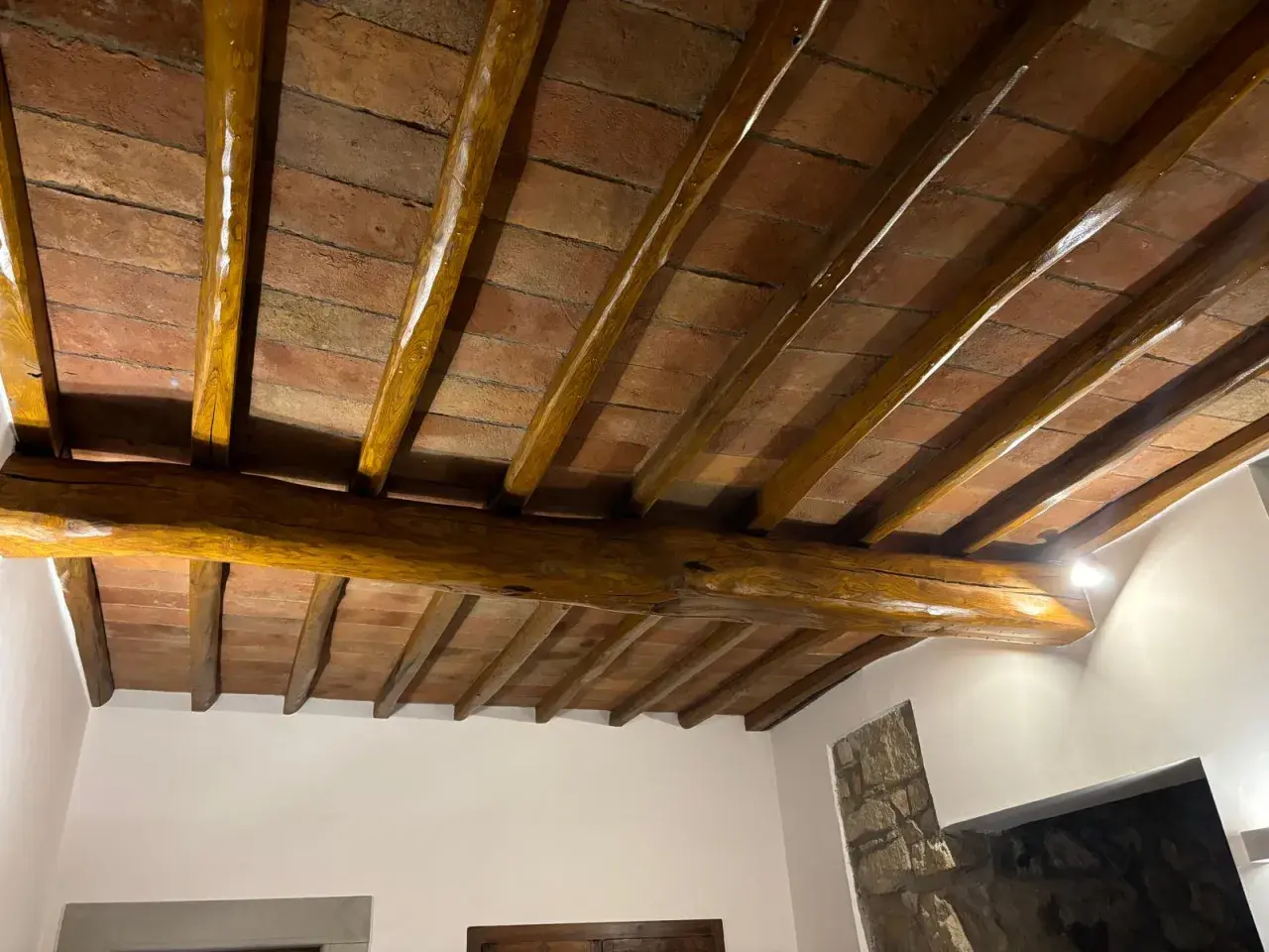 Travi in legno con tetto in cotto, protette da un efficace trattamento antitarlo per preservare la bellezza storica.