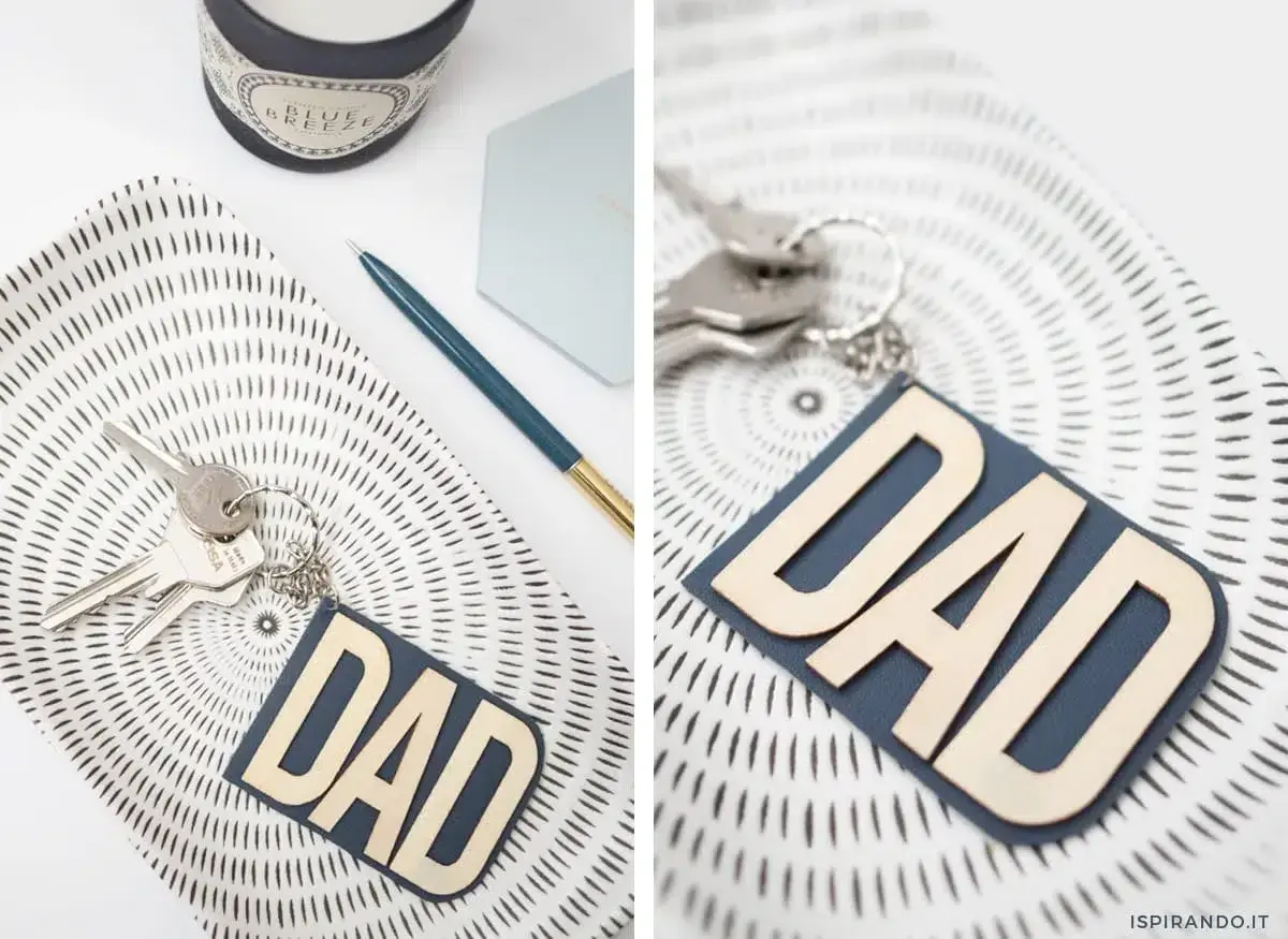 Portachiavi fai da te per la festa del papà con scritta "DAD" in legno su fondo blu. Un'idea regalo originale e personalizzata.