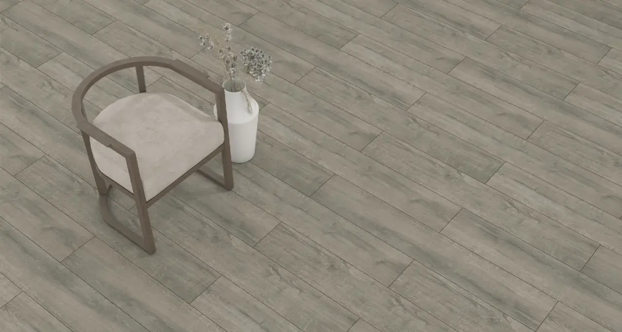 Sedia beige e vaso con fiori secchi su un pavimento in laminato grigio effetto legno. Lo spessore del parquet laminato è ideale per ogni ambiente.