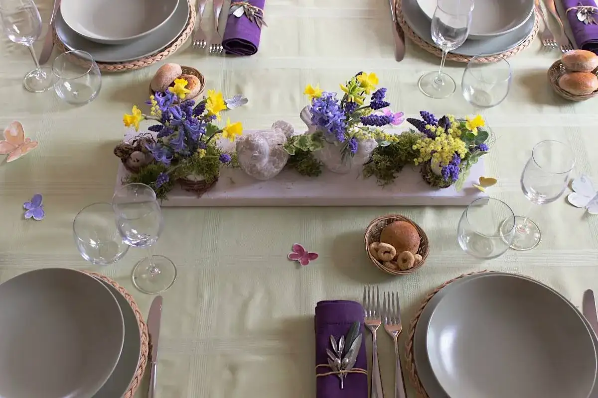 Tavola apparecchiata per Pasqua con centrotavola di fiori e uccellini, idee per lavoretti per pasqua.