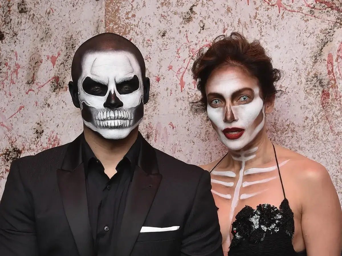 Coppia con trucco da teschio, un esempio di costumi horror fai da te per Halloween.