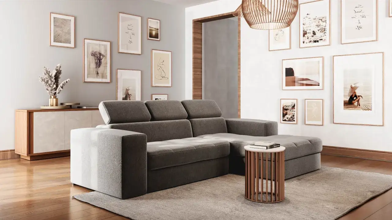 Soggiorno moderno con divano angolare grigio, tavolino rotondo e un mix and match di quadri alle pareti.
