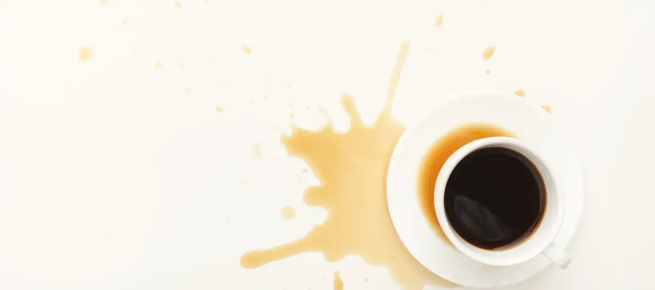 Macchie di caffè su cotone bianco, un disastro mattutino.