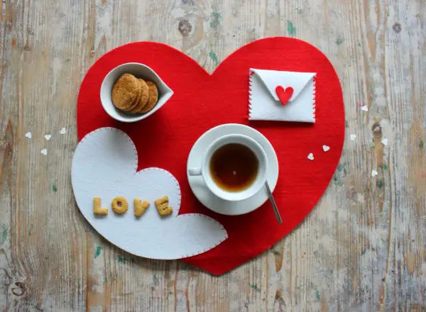 Tovagliette colazione fai da te a forma di cuore, con biscotti, tè e una busta con un cuore.