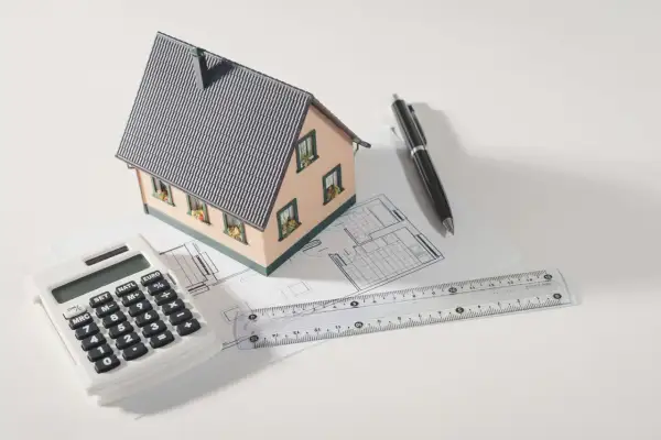 Modello di casa, calcolatrice, righello e penna su progetto. Pianifica la tua ristrutturazione con sconto in fattura.