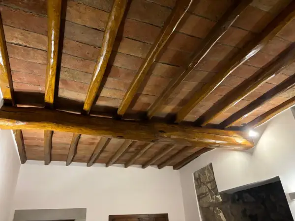 Travi in legno con tetto in cotto, protette da un efficace trattamento antitarlo per preservare la bellezza storica.