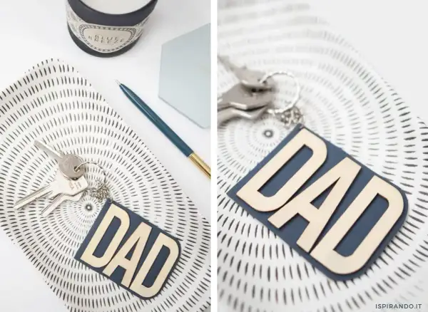 Portachiavi fai da te per la festa del papà con scritta "DAD" in legno su fondo blu. Un'idea regalo originale e personalizzata.
