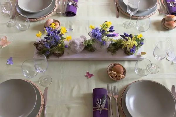 Tavola apparecchiata per Pasqua con centrotavola di fiori e uccellini, idee per lavoretti per pasqua.