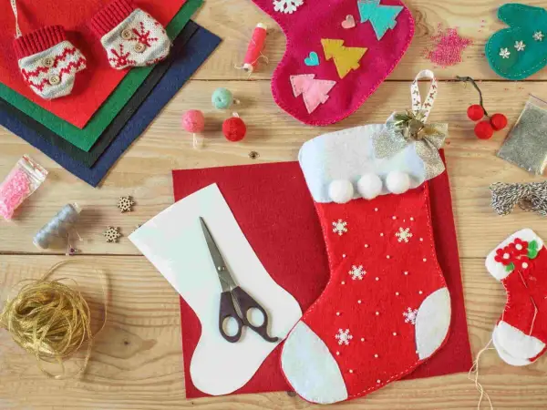 Materiali per calze Befana personalizzate fai da te: feltro, forbici, nastri, bottoni e perline per creare decorazioni uniche.