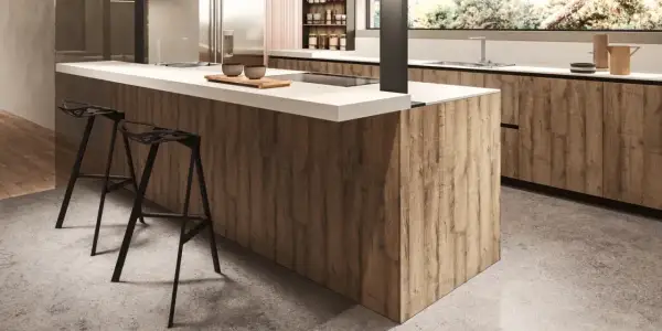 Modern kitchen island with wood-look melamine cabinets and white countertop, featuring black bar stools.