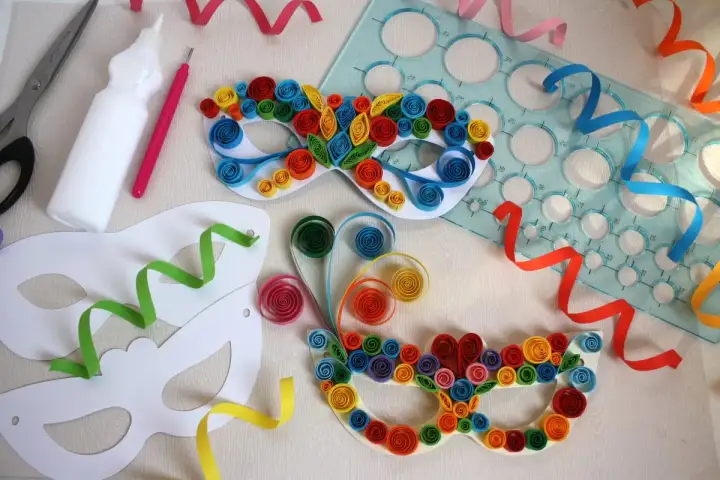 Maschere di carnevale da realizzare con i bambini: forbici, colla, stencil e strisce colorate per creare capolavori di quilling.
